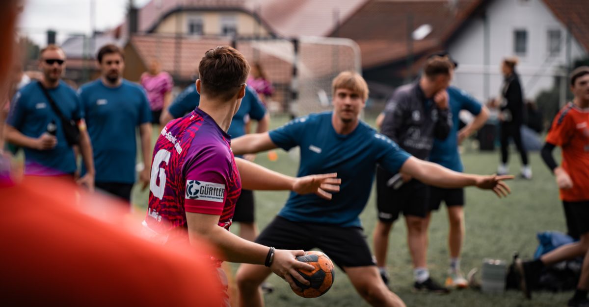 Outdoor handball practice session with players in action on a sports field in Oberviechtach, Germany.